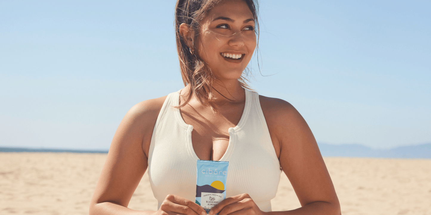 A girl in a swimming suit holding a cibare bar