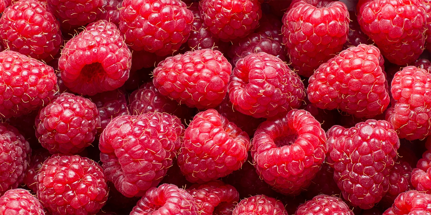 Close-up of a cluster of vibrant red raspberries. The berries are plump and fresh, with a textured surface, conveying a sense of ripeness and juiciness.
