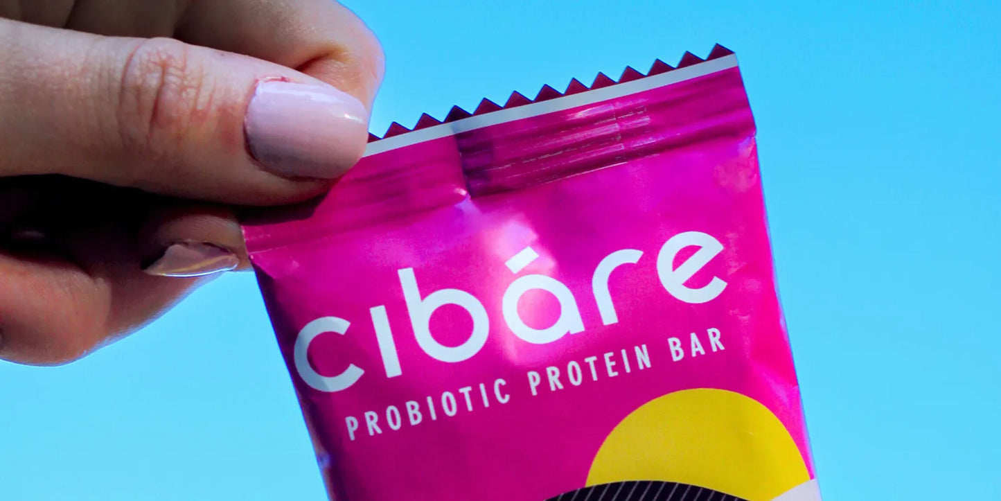 A person holding a bag of Cibare protein bar, showcasing the product's packaging and branding.